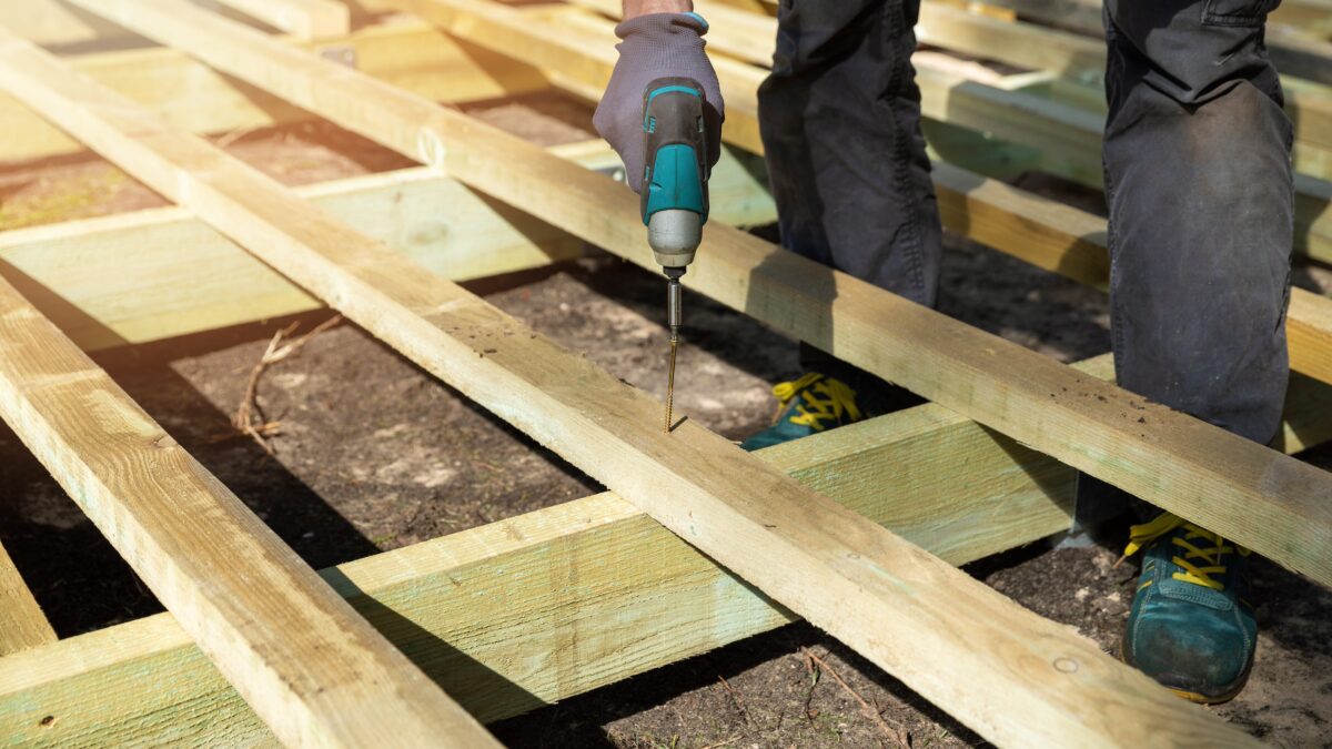 Person building wooden frame for ground level deck
