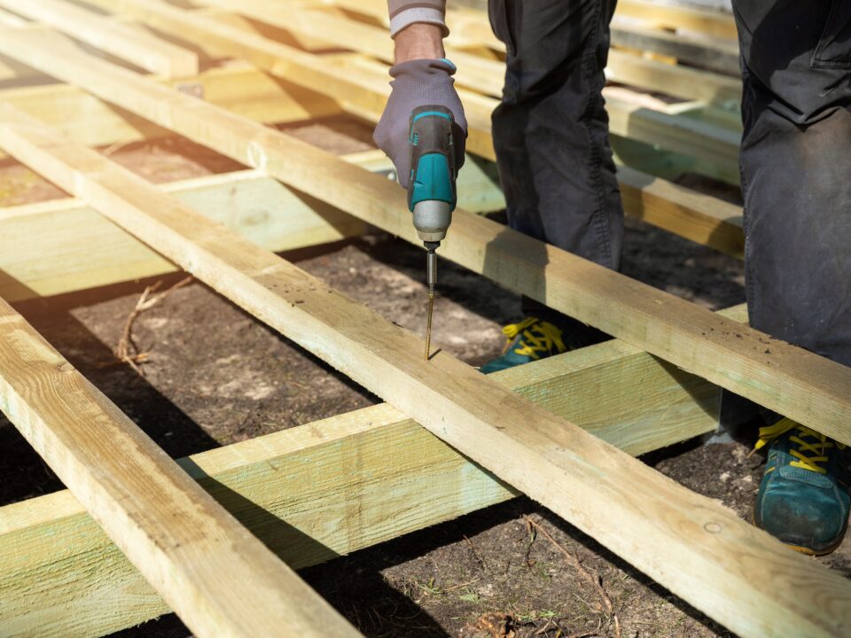 Person building wooden frame for ground level deck