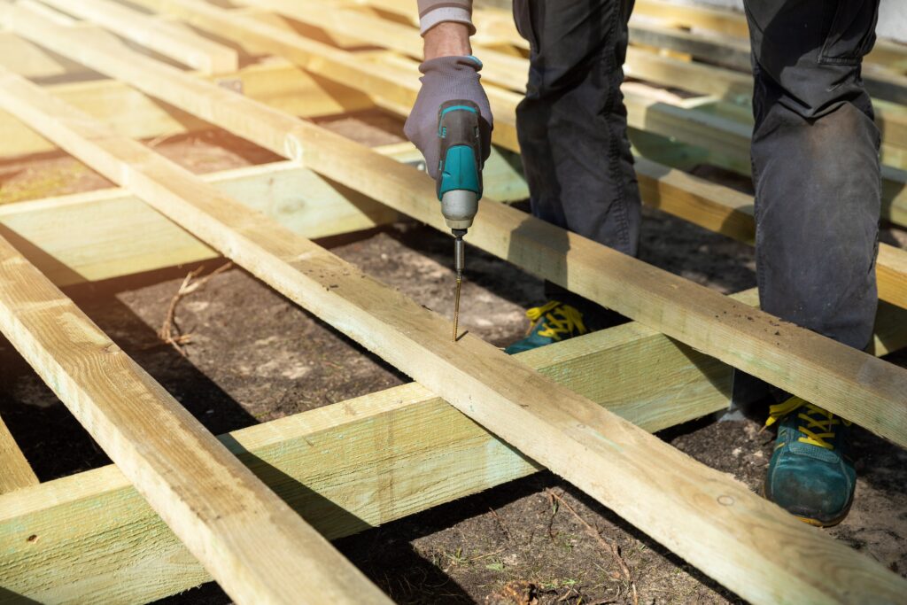 Person building wooden frame for ground level deck