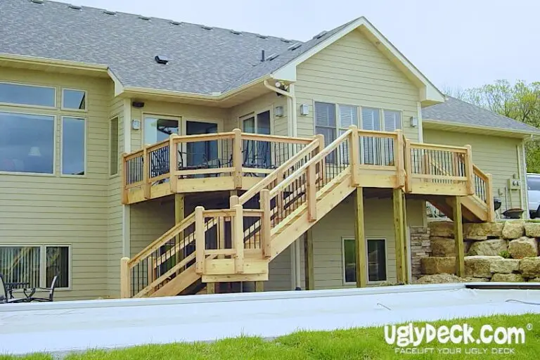 Two-story house with a newly built wood deck and staircase—perfect for DIY deck materials enthusiasts—leading to the backyard; light-colored siding, large windows, and the UglyDeck.com logo in the bottom right corner.