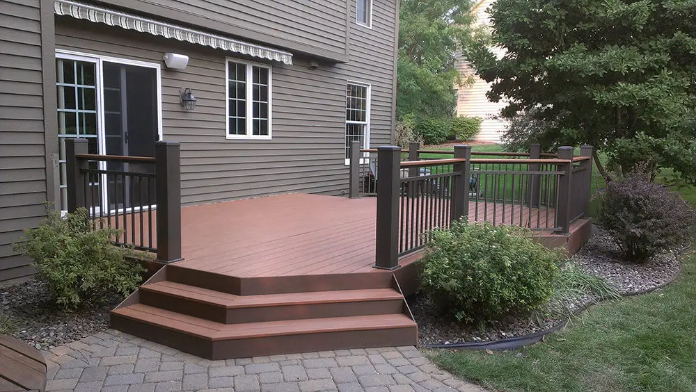 Ground level deck from UglyDeck with brown decking materials and railing.